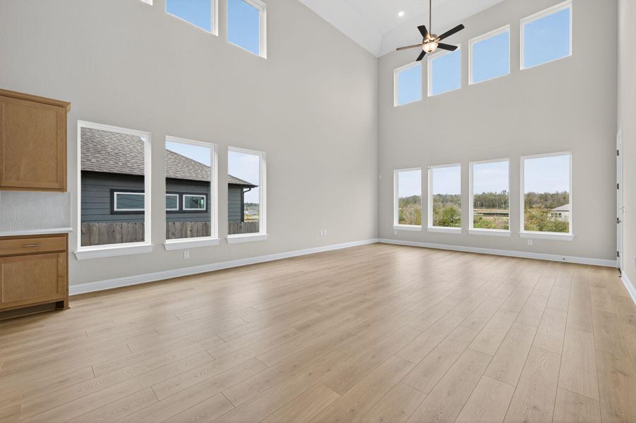 Unfurnished living room featuring light wood-type flooring and ceiling fan