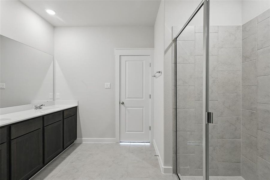 Bathroom with double vanity and a shower stall
