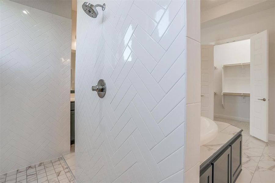 Bathroom with tiled shower and vanity