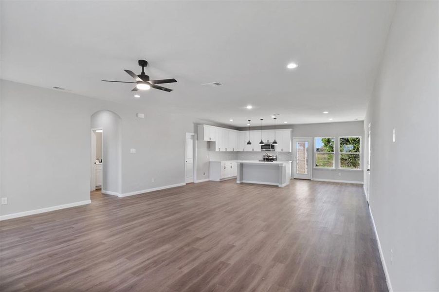 Unfurnished living room featuring hardwood / wood-style flooring and ceiling fan