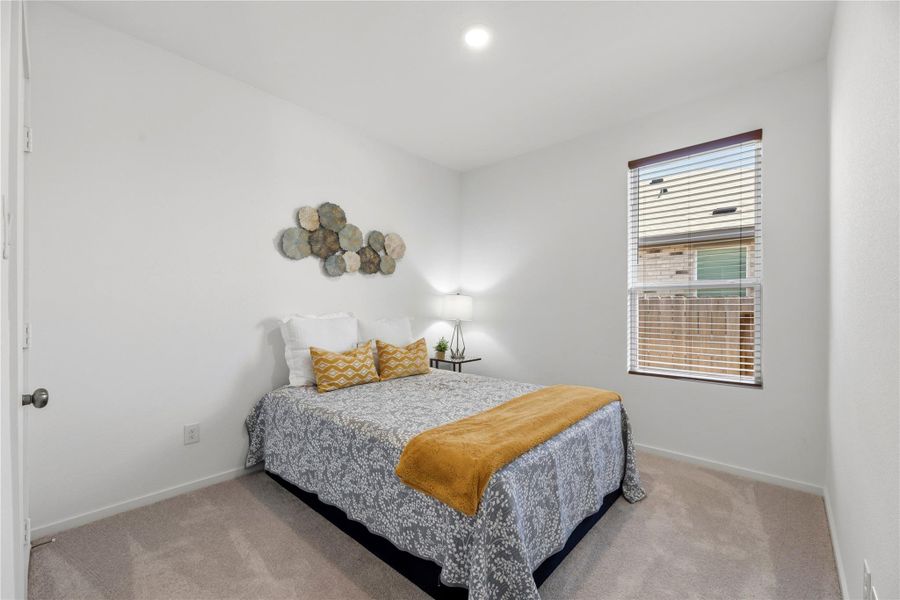 Secondary bedroom with soft natural light, neutral tones, and flexible layout perfect for guests or personal space.