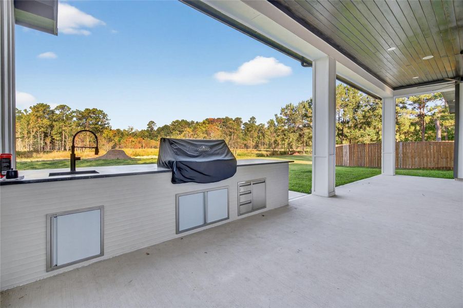 Spacious covered patio overlooks the expansive lawn and provides a comfortable setting for year-round outdoor enjoyment. **Images are from a previously completed project. **