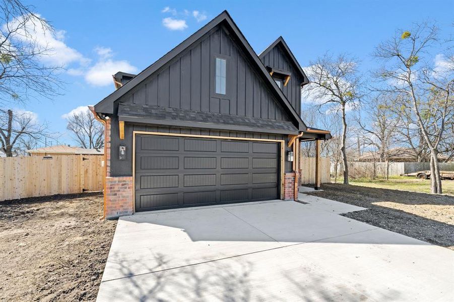 Garage with fence and concrete driveway