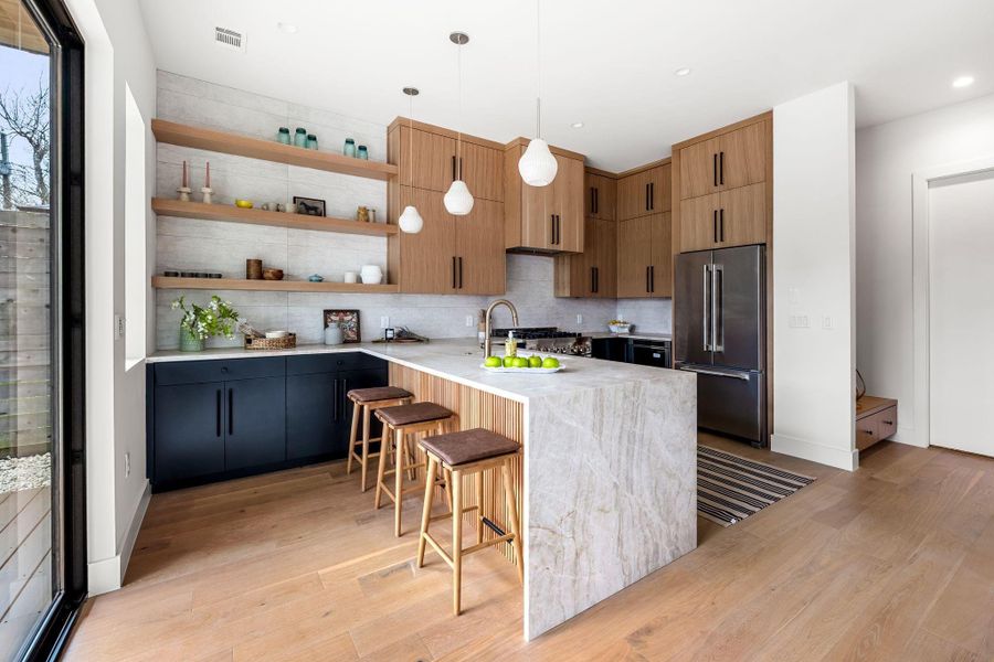 Kitchen featuring open shelves, custom cabinetry and plenty of storage