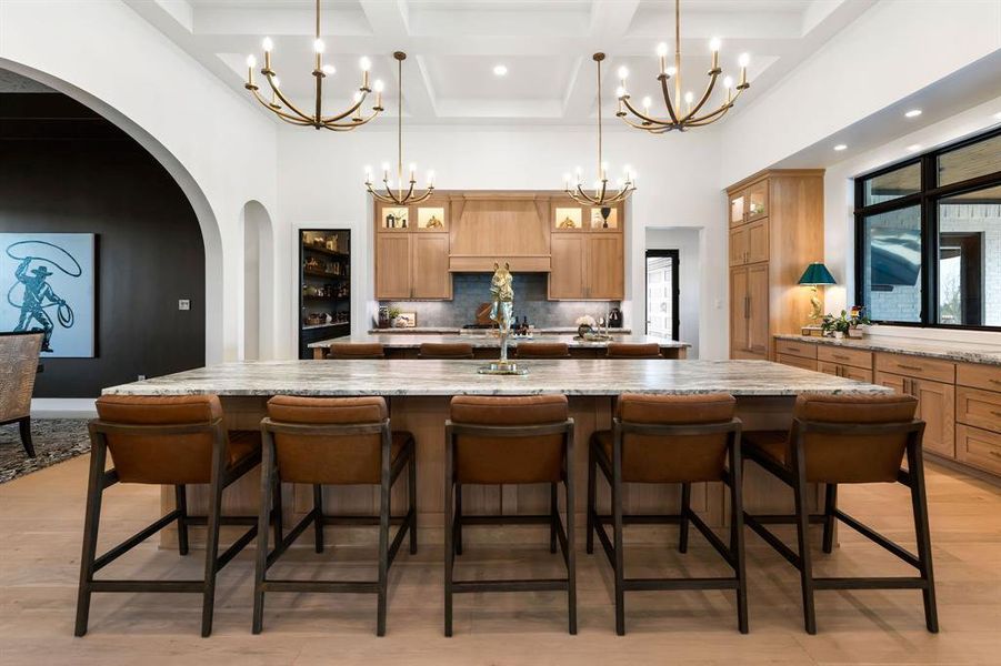 Kitchen with a towering ceiling, arched walkways, glass insert cabinets, backsplash, and coffered ceiling Kitchen with a towering ceiling, arched walkways, glass insert cabinets, backsplash, and coffered ceiling