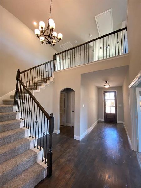 Impressive entry with cathedreal ceiling, ORB chandelier, and wrought iron spindles on the staircase