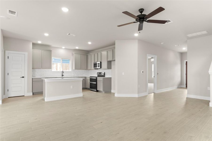 Kitchen with gray cabinetry, appliances with stainless steel finishes, tasteful backsplash, and recessed lighting Kitchen with gray cabinetry, appliances with stainless steel finishes, tasteful backsplash, and recessed lighting