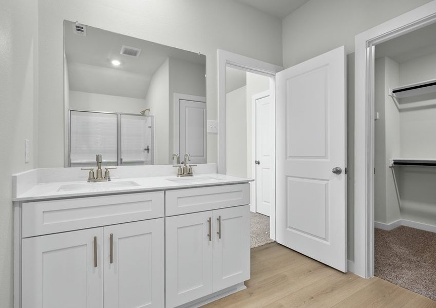 The master bath includes a double-sink vanity and access to the walk-in closet.