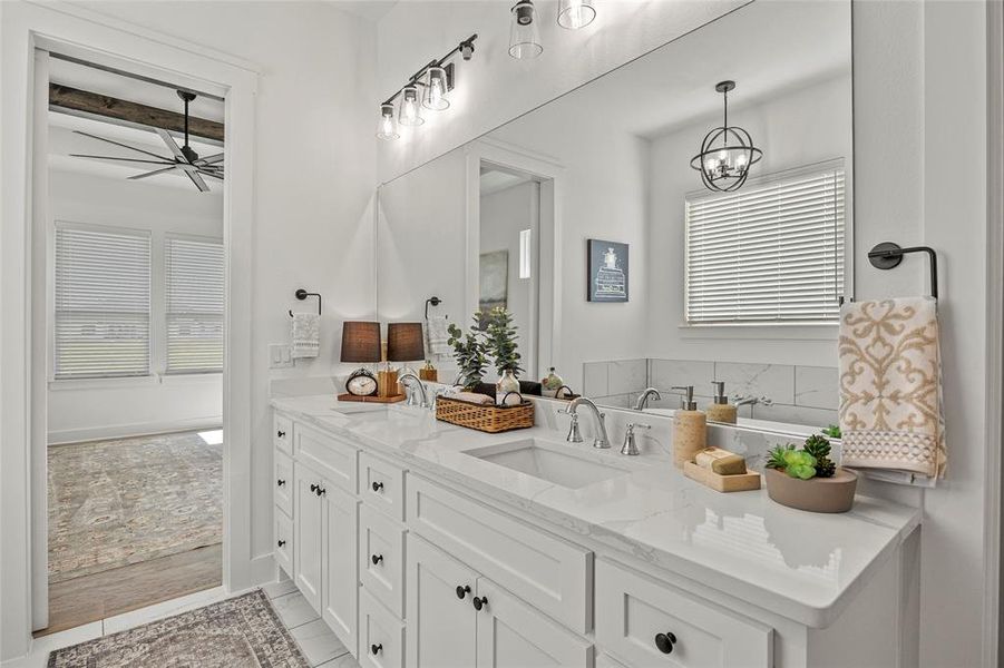 Bathroom featuring a bathing tub, tile patterned flooring, dual bowl vanity, and a healthy amount of sunlight