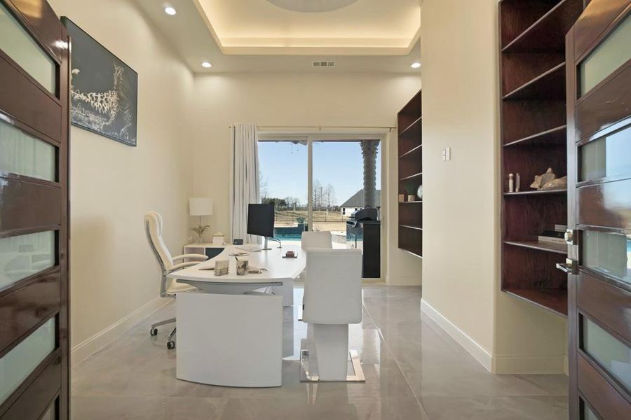 Office with a tray ceiling and built in features