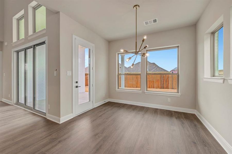 Unfurnished dining area featuring a chandelier and light wood-style floors