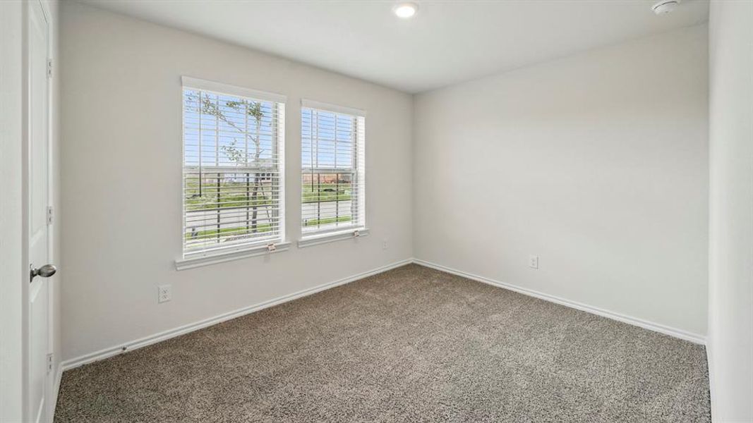 Room featuring two windows with white blinds, gray carpet, white baseboards, and light-toned walls