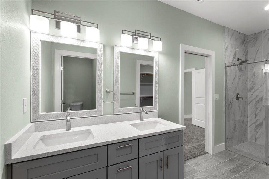 Primary Full bath featuring a marble finish shower, double vanity, and a closet