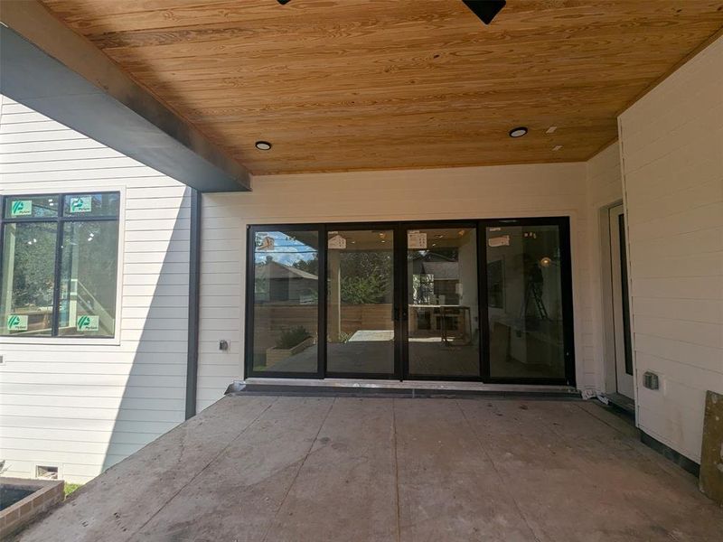 Rear patio with additional exterior entry to pool/guest house.