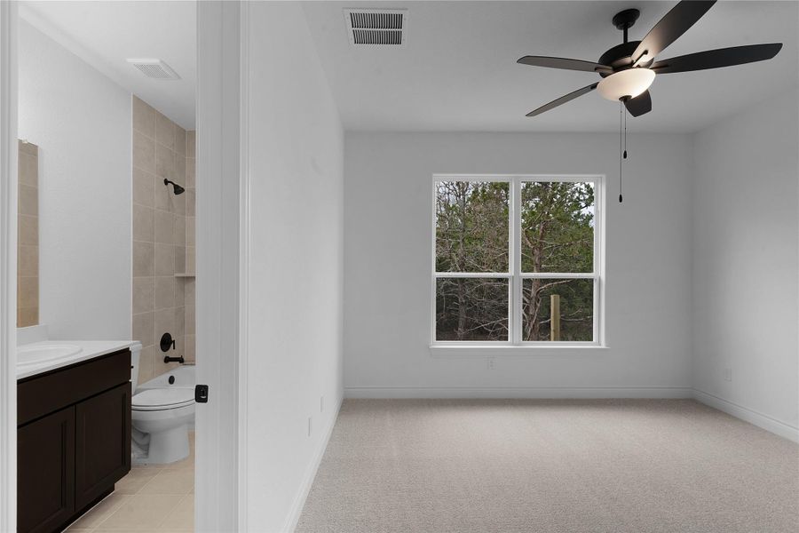 Bathroom with ceiling fan, vanity, light carpet, and bathtub / shower combination