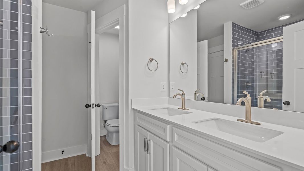 Superior en-suite primary bathroom with stylish dual vanity and tiled walk-in shower crafted with high standards in mind