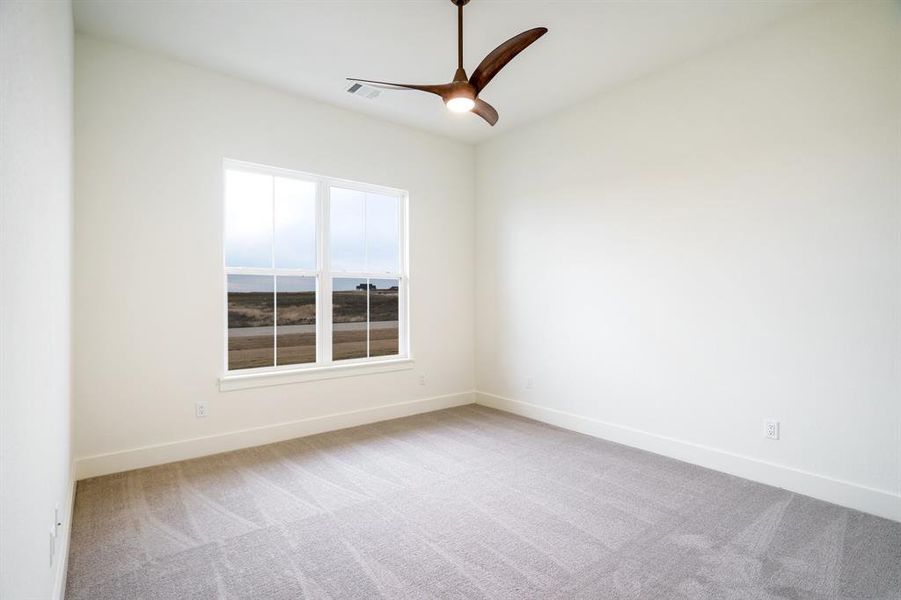 Empty room featuring ceiling fan and light colored carpet