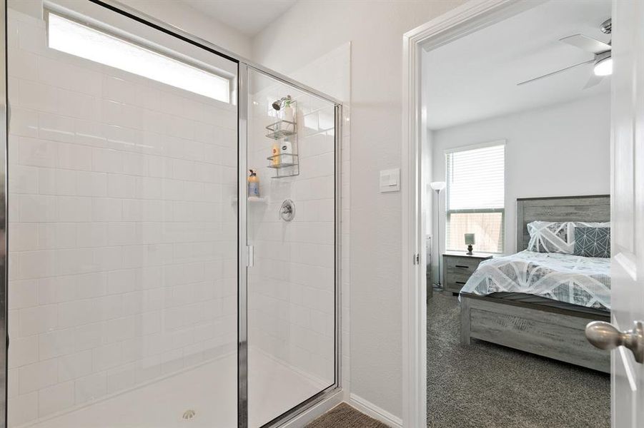 Full bath featuring a stall shower, a ceiling fan, and connected bathroom