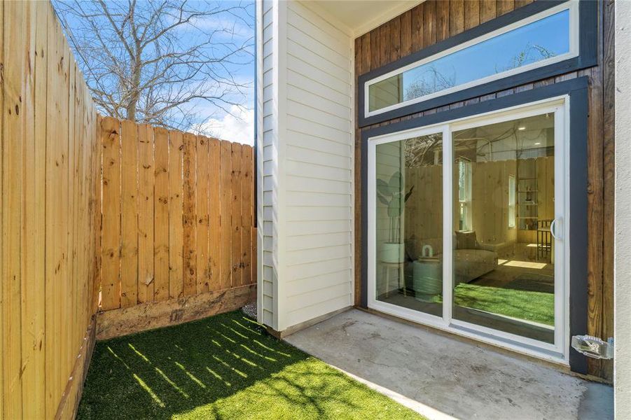 This inviting backyard features a sheltered porch and a curated green space for relaxation.