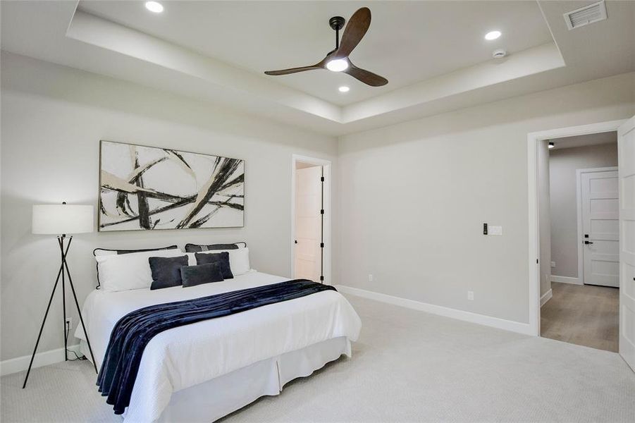 Carpeted bedroom featuring a tray ceiling, a ceiling fan, and recessed lighting Carpeted bedroom featuring a tray ceiling, a ceiling fan, and recessed lighting