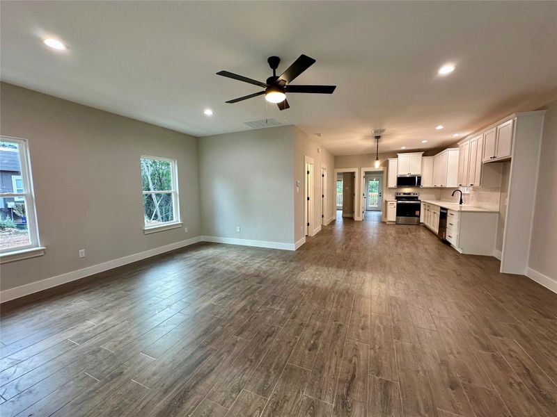 Unfurnished living room featuring recessed lighting, dark wood-style floors, and a ceiling fan Unfurnished living room featuring recessed lighting, dark wood-style floors, and a ceiling fan