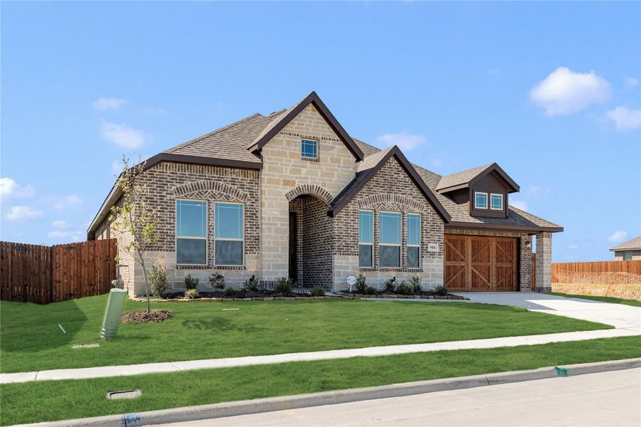 Single-story home with brick and stone exterior, arched entry, two-car garage, and green front lawn Single-story home with brick and stone exterior, arched entry, two-car garage, and green front lawn