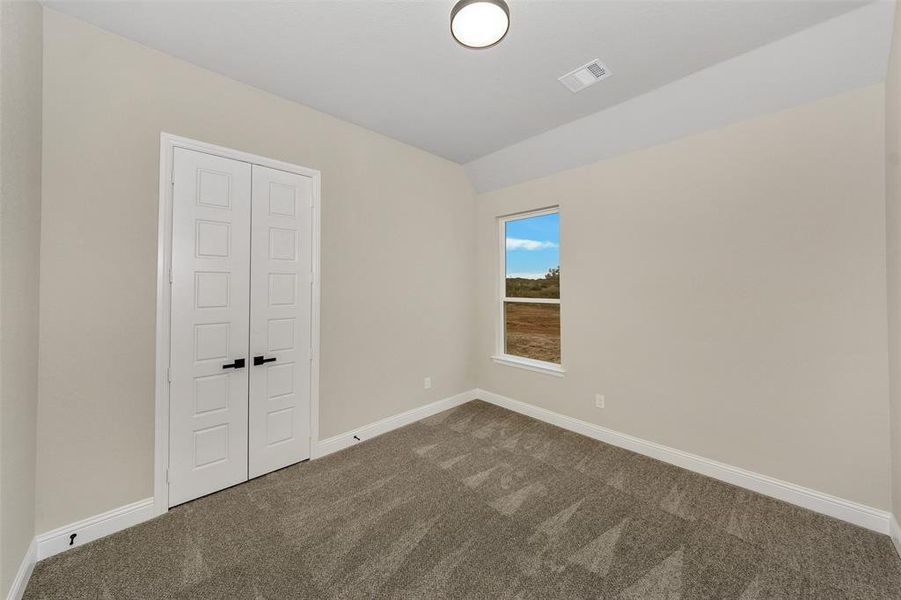 Unfurnished room featuring carpet flooring and vaulted ceiling