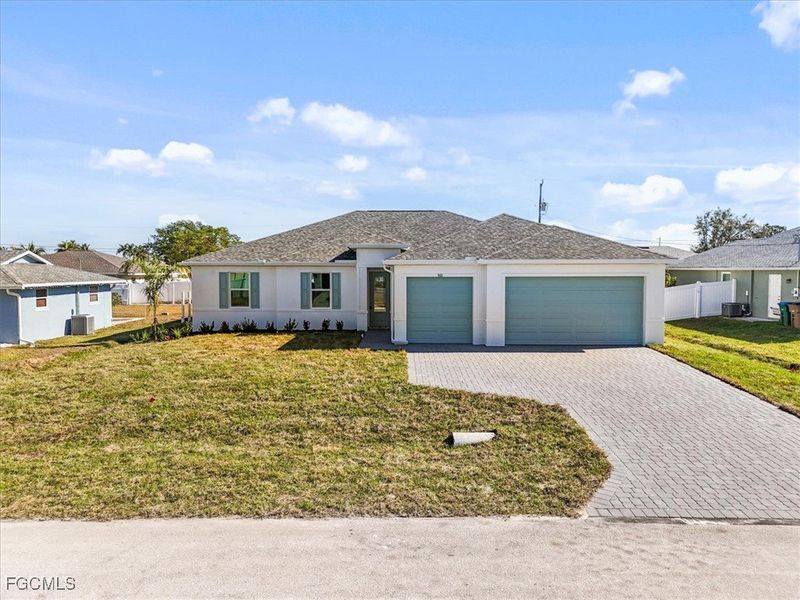 View of front of home with decorative driveway, an attached garage, stucco siding, and a shingled roof