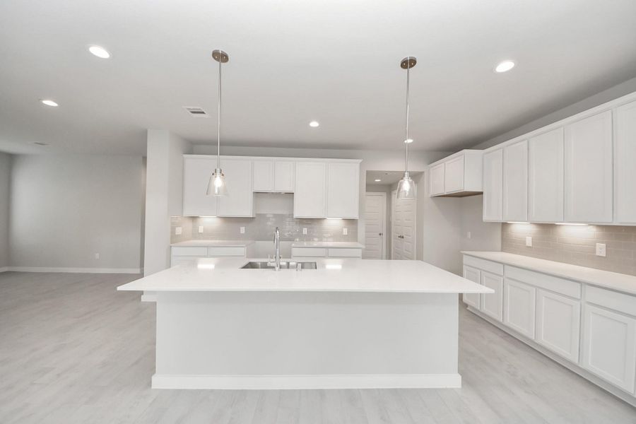 This generously spacious kitchen is a dream realized! With a massive granite island, high ceilings, soft close cabinets, granite countertops, stainless steel appliances (To be Installed), a sleek tile backsplash, recessed lighting, and an extended counter area, it offers both style and practicality. All this opens up to the expansive family room, creating a perfect hub for gatherings. Sample photo of completed home with similar floor plan. Actual colors and selections may vary. This generously spacious kitchen is a dream realized! With a massive granite island, high ceilings, soft close cabinets, granite countertops, stainless steel appliances (To be Installed), a sleek tile backsplash, recessed lighting, and an extended counter area, it offers both style and practicality. All this opens up to the expansive family room, creating a perfect hub for gatherings. Sample photo of completed home with similar floor plan. Actual colors and selections may vary.