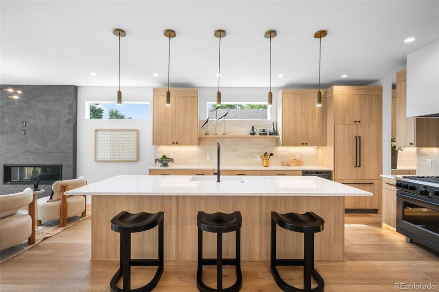 Spacious chefs kitchen with custom cabinetry, café appliances, quartz countertops and kick toe lighting