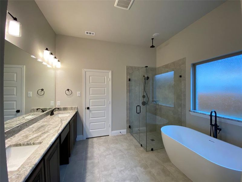 Spa-like master bath with freestanding tub, walk-in shower, and 12x24 oversized tile