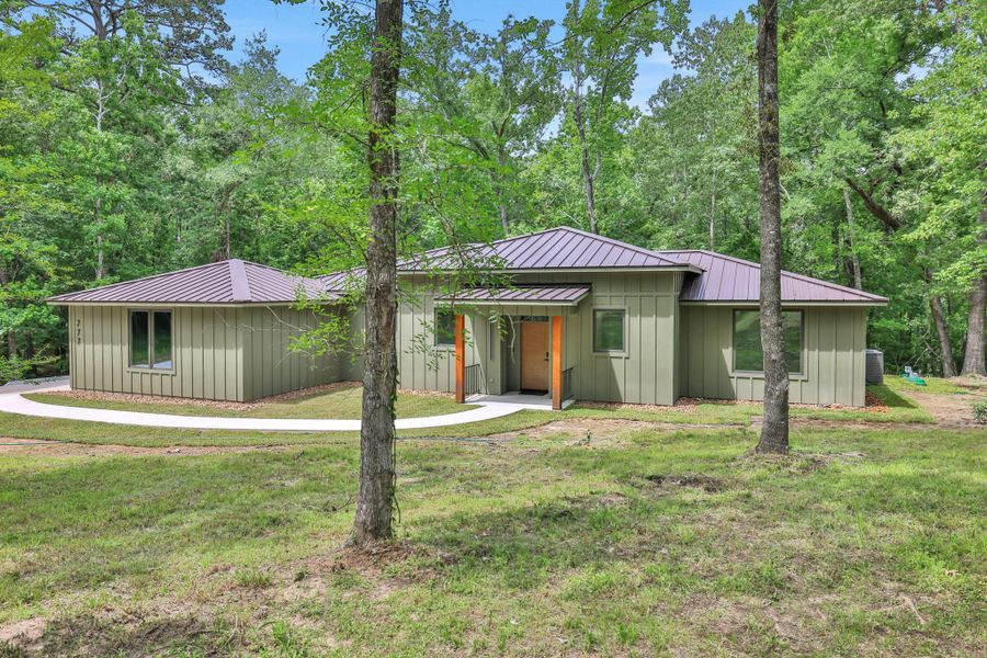 Contemporary design meets nature - clean architecture surrounded by lush, wooded views.