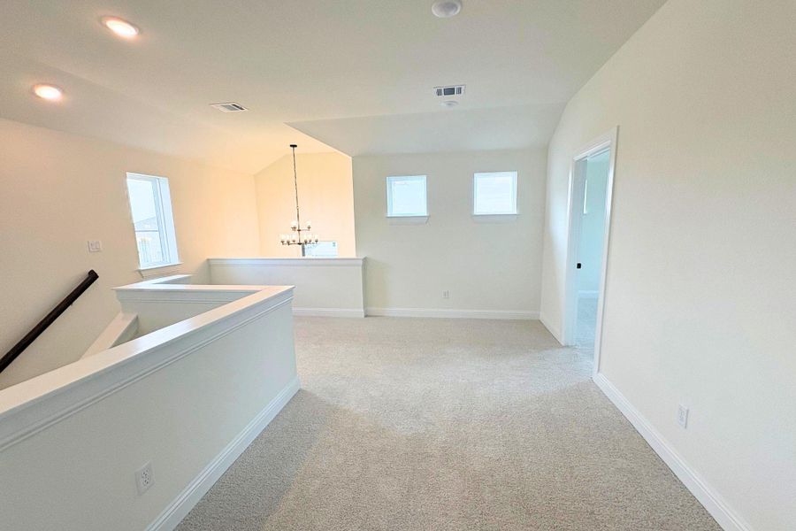 A spacious upper-level loft features wall-to-wall carpeting and neutral architectural finishes. A spacious upper-level loft features wall-to-wall carpeting and neutral architectural finishes.