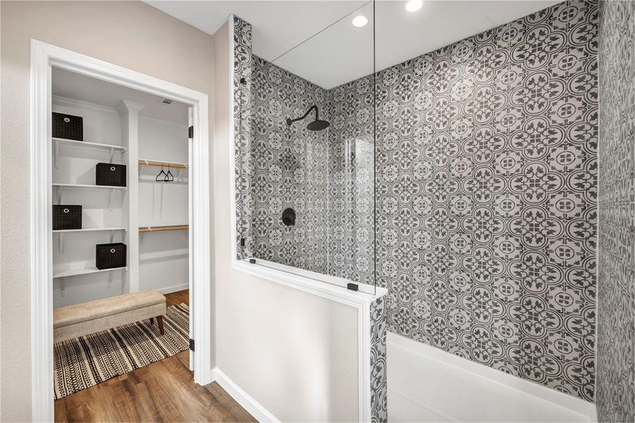 Full bath featuring a walk in closet, walk in shower, wood finished floors, and recessed lighting