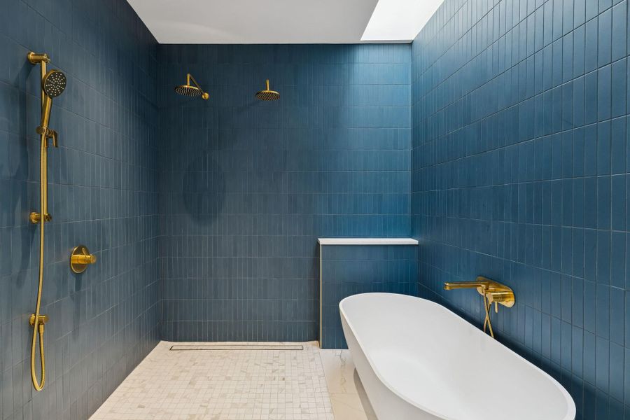 Primary Bathroom featuring tile walls, tiled shower, and a freestanding tub