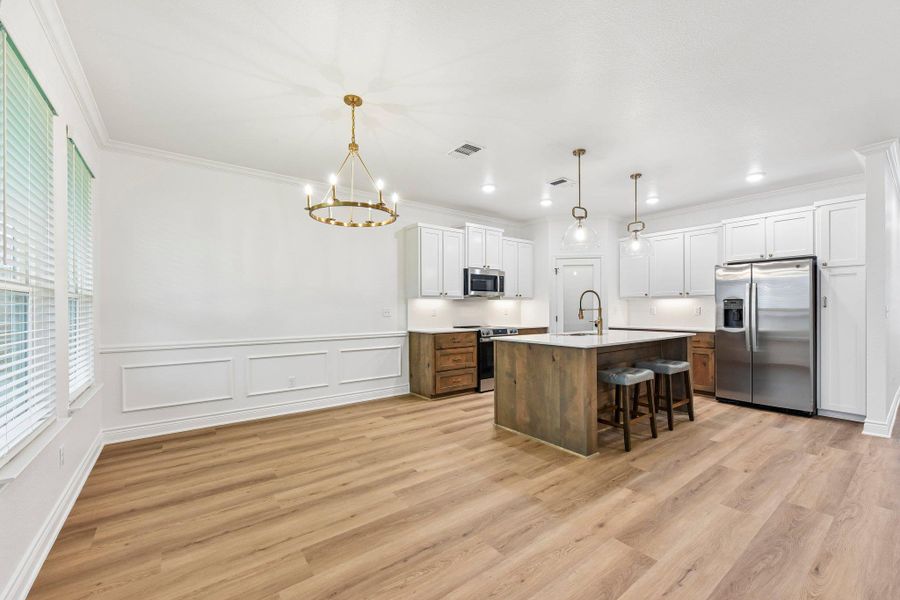 An open concept kitchen and dining space combines casual elegance with modern functionality. An open concept kitchen and dining space combines casual elegance with modern functionality.