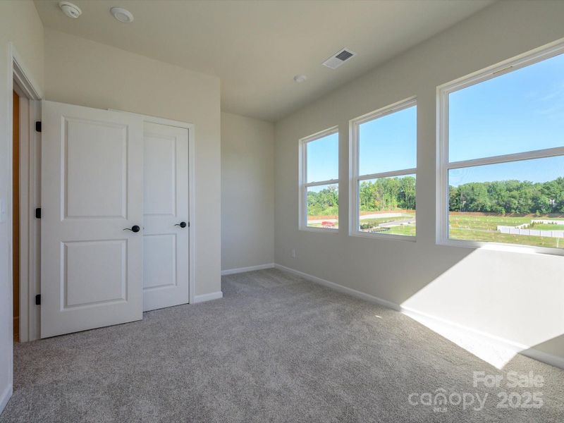 Secondary bedroom with wall of windows to open up the space.