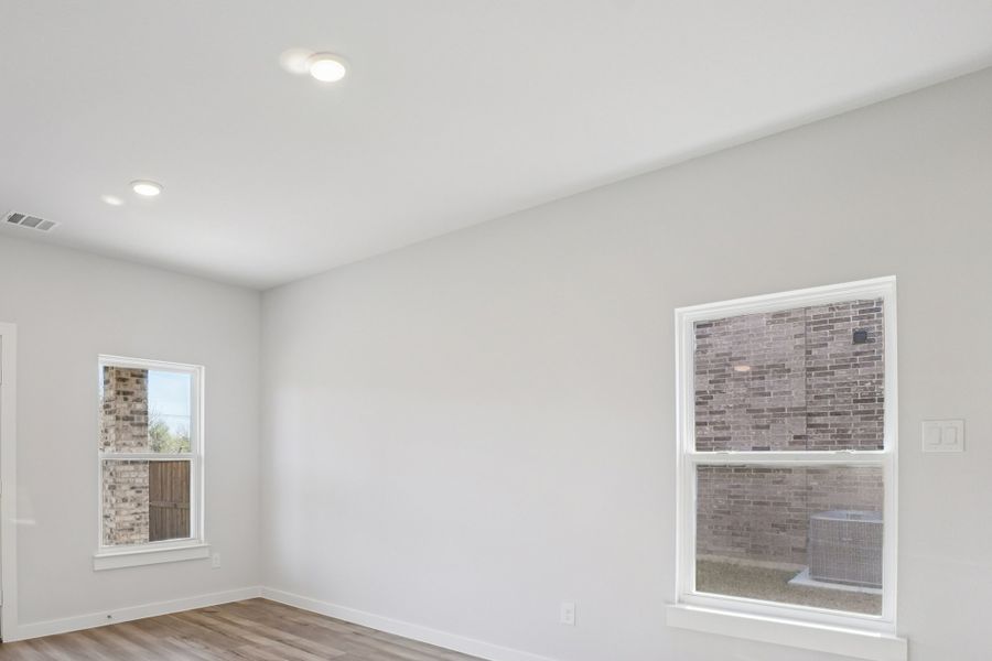A room with a window and a wood floor.