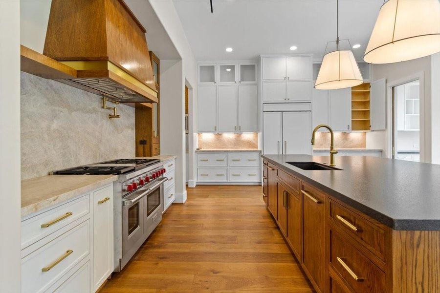 The appliances are paneled - dishwasher in island has an oak panel and Sub Zero in back ground has white panels.  The 48" Wolf range includes a griddle and is flanked by Oak towers.