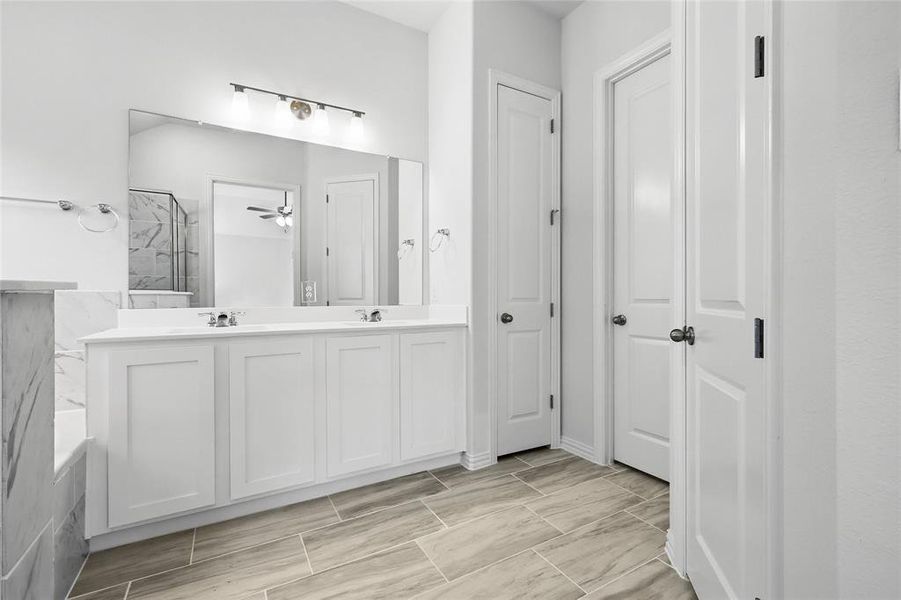 Full bathroom with double vanity, a sink, and walk in shower