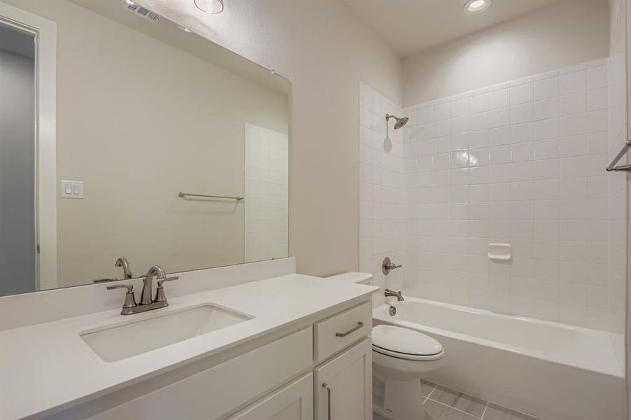 Full bathroom with bathing tub / shower combination, vanity, light tile patterned floors, and recessed lighting
