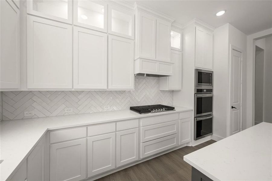 Kitchen featuring white cabinets, stainless steel appliances, dark wood-style flooring, light stone counters, and recessed lighting