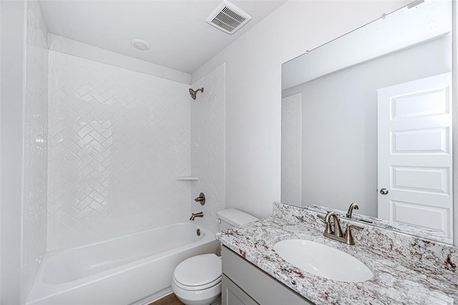 Secondary bathroom offers granite countertops with a garden style tub/shower