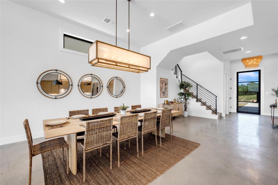 Polished concrete floors and high ceilings define this light-filled modern dining area.
