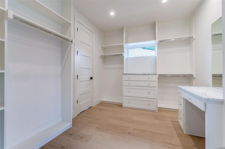 Walk in closet featuring light wood-type flooring Walk in closet featuring light wood-type flooring