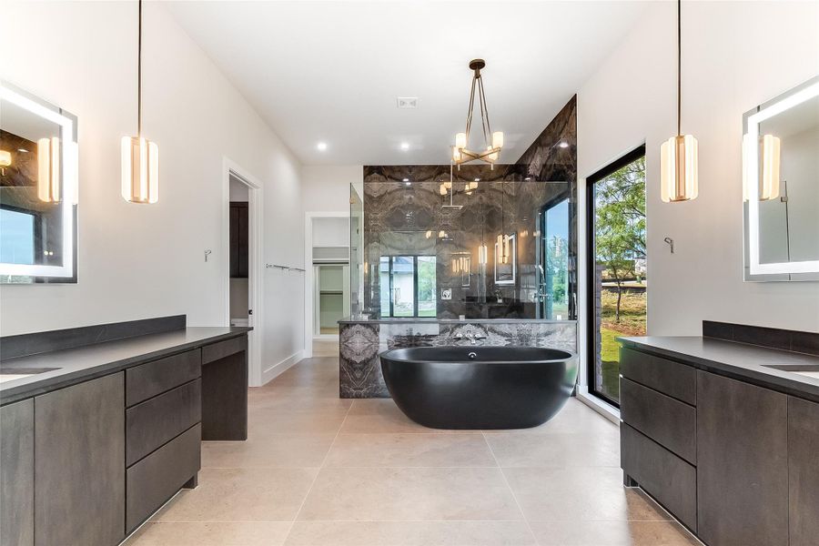 Full bath with a shower stall, a soaking tub, two vanities, tile patterned flooring, and a chandelier Full bath with a shower stall, a soaking tub, two vanities, tile patterned flooring, and a chandelier