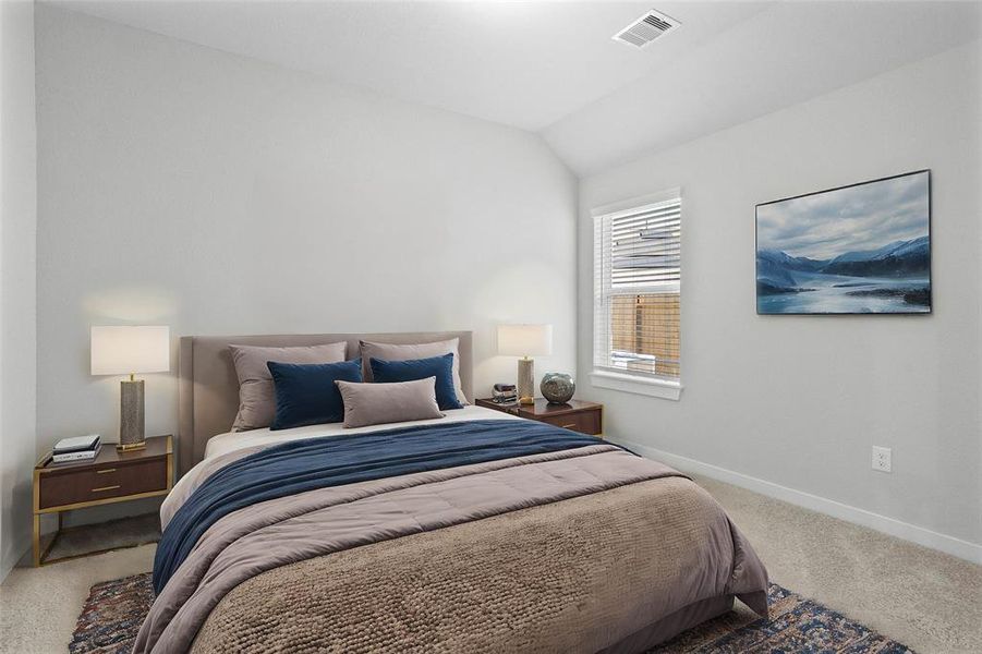 Secondary bedroom features plush carpet, custom paint, lighting, and a large windows with privacy blinds.