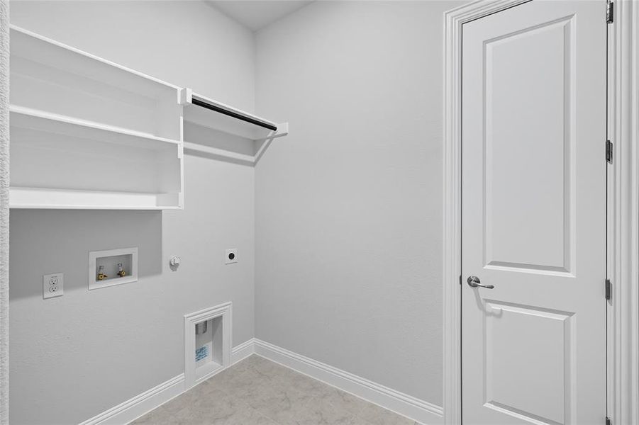 Washroom featuring hookup for a gas dryer, hookup for an electric dryer, washer hookup, and light tile patterned flooring Washroom featuring hookup for a gas dryer, hookup for an electric dryer, washer hookup, and light tile patterned flooring