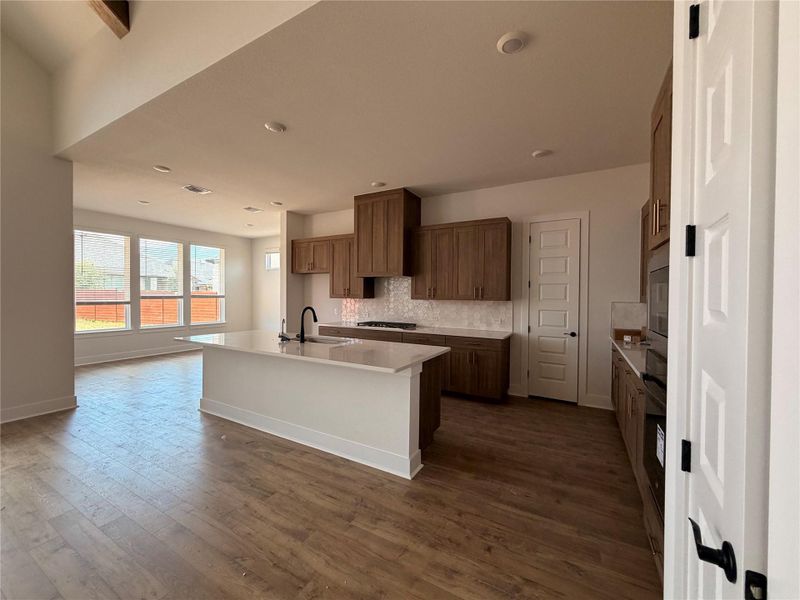 An open concept kitchen features warm wood cabinetry and a functional island with integrated sink. An open concept kitchen features warm wood cabinetry and a functional island with integrated sink.