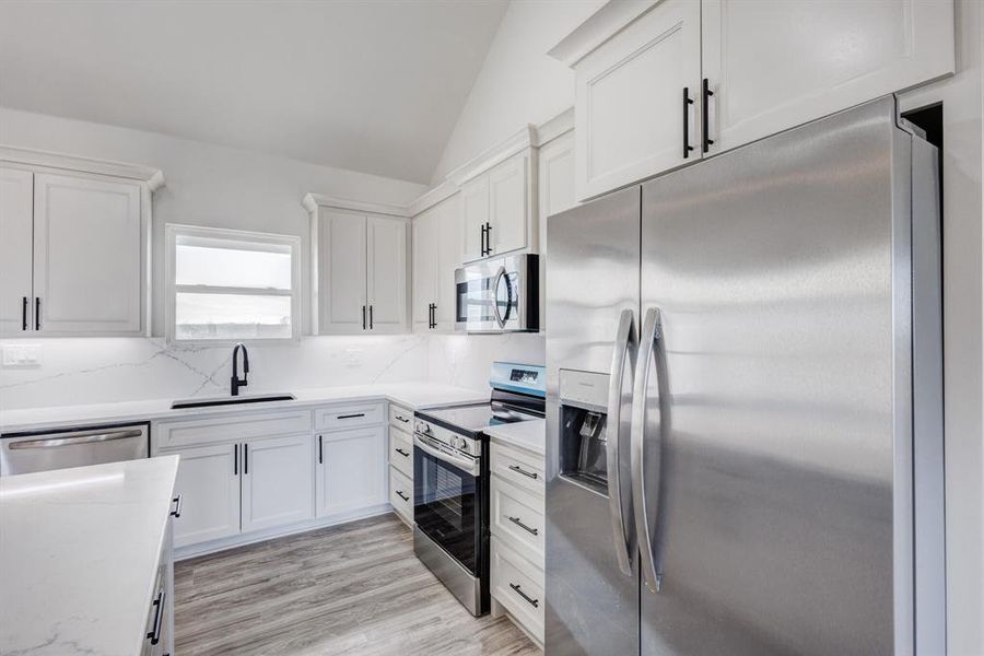 Kitchen with white cabinets, sink, and appliances with stainless steel finishes